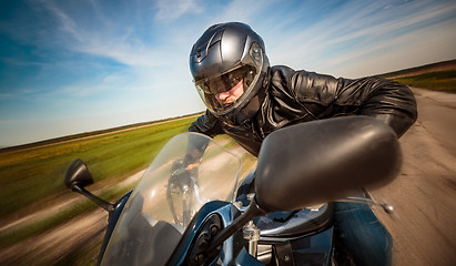 Image showing Biker racing on the road