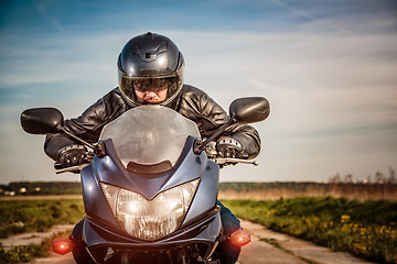 Image showing Biker racing on the road