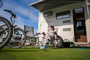 Image showing Woman resting near motorhomes in nature. Family vacation travel,