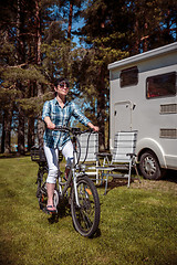 Image showing Woman on electric bike resting at the campsite VR Caravan car Va