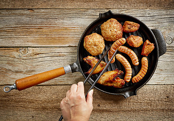 Image showing various roasted meat on cast iron pan