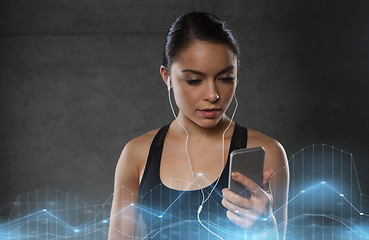 Image showing woman with smartphone and earphones in gym