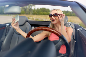 Image showing woman in convertible car taking selfie