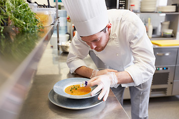 Image showing happy male chef cooking food at restaurant kitchen