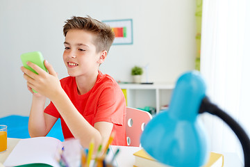 Image showing student boy with smartphone distracting from study