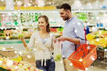 Image showing happy couple buying apples at grocery store