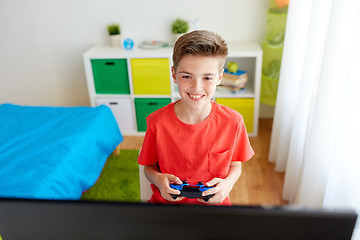 Image showing boy with gamepad playing video game on computer