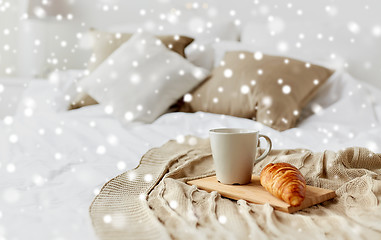 Image showing coffee cup and croissant on plaid in bed at home