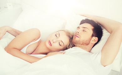 Image showing happy couple sleeping in bed at home