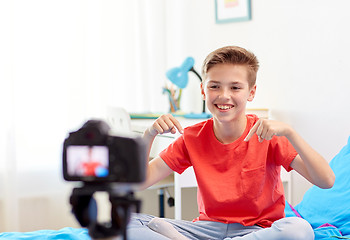 Image showing happy boy with camera recording video at home