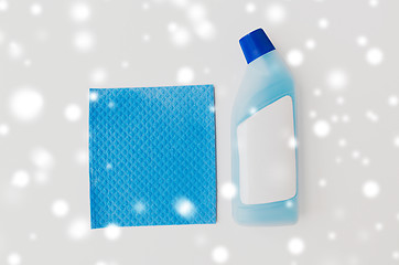 Image showing bottle of detergent and blue rag on white