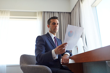 Image showing businessman with papers working at hotel room