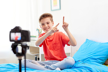 Image showing happy boy with camera recording video at home