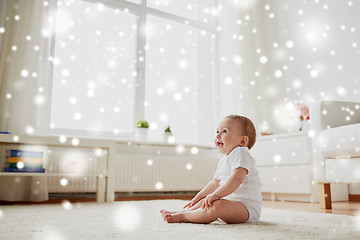 Image showing happy baby boy or girl sitting on floor at home