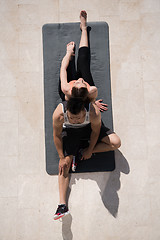 Image showing woman with personal trainer doing morning yoga exercises top vie