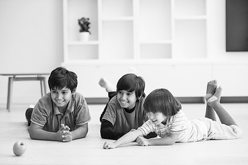 Image showing boys having fun with an apple on the floor