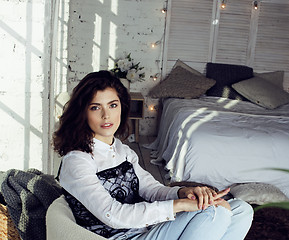 Image showing young pretty brunette woman in her bedroom sitting at window, happy smiling lifestyle people concept 