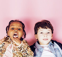 Image showing lifestyle people concept: diverse nation children playing together, caucasian boy with african little girl holding candy happy smiling 