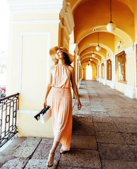 Image showing young pretty smiling woman in hat with bags on shopping at store