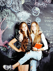 Image showing back to school after summer vacations, two teen real girls in classroom with blackboard painted together, lifestyle people concept