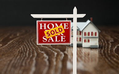 Image showing Sold For Sale Real Estate Sign In Front of Model Home on Reflect