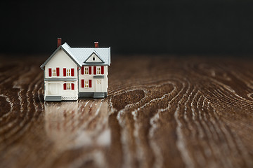 Image showing Model Home on Reflective Wooden Surface.