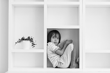 Image showing young boy posing on a shelf