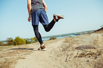 Image showing Running sport. Man runner sprinting outdoor in scenic nature. Fit muscular male athlete training trail running for marathon run.