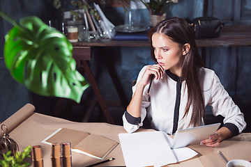 Image showing Young beautiful woman working with cup of coffee