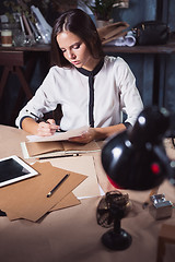 Image showing Young beautiful woman working with cup of coffee