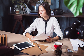 Image showing Young beautiful woman working with cup of coffee