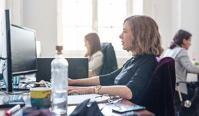 Image showing Yound devoted female software developers team working on desktop computer in IT statup company.