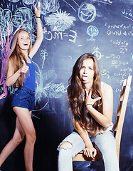 Image showing back to school after summer vacations, two teen girls in classroom with blackboard painted