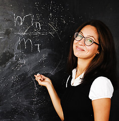 Image showing portrait of happy cute real teen student in classroom at blackboard close up, lifestyle education people concept
