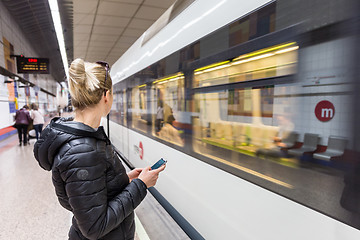 Image showing Woman with a cell phone waiting for metro.