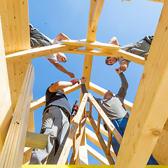 Image showing Builders at work with wooden roof construction.