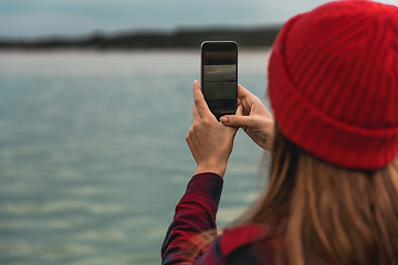 Image showing Woman taking pictures with a cellphone