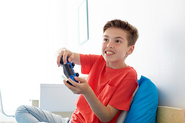 Image showing happy boy with gamepad playing video game at home