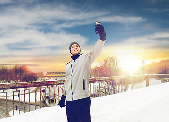 Image showing man taking selfie with smartphone in winter 