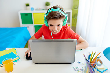 Image showing boy in headphones playing video game on laptop