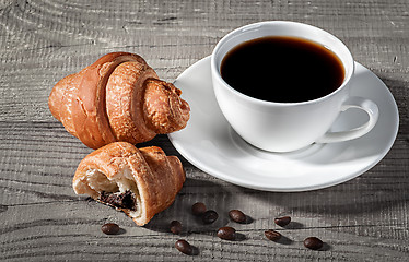 Image showing Coffee and croissants on a wooden table