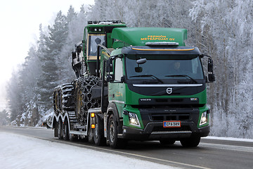 Image showing Green Volvo FMX Truck Hauls John Deere Forestry Machinery