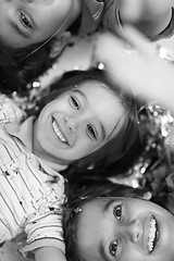 Image showing kids  blowing confetti while lying on the floor