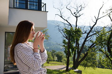 Image showing woman in a bathrobe enjoying morning coffee