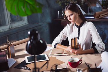 Image showing Young beautiful woman working with cup of coffee