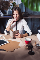 Image showing Young beautiful woman working with cup of coffee