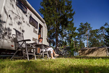 Image showing Woman resting near motorhomes in nature. Family vacation travel,