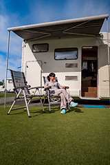 Image showing Woman resting near motorhomes in nature. Family vacation travel,