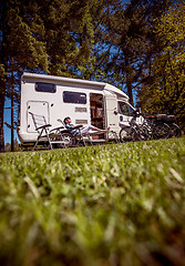 Image showing Woman resting near motorhomes in nature. Family vacation travel,