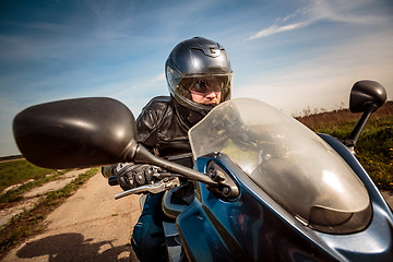 Image showing Biker racing on the road